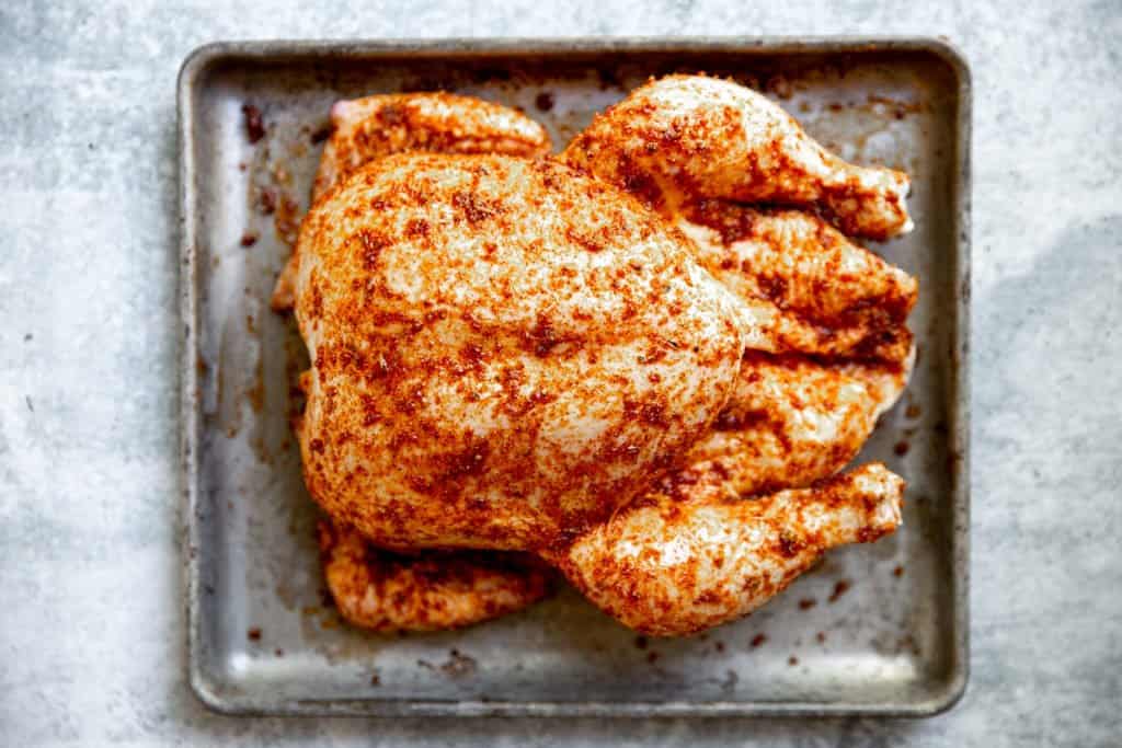 Season the chicken generously with your preferred rub to Smoked Whole Chicken