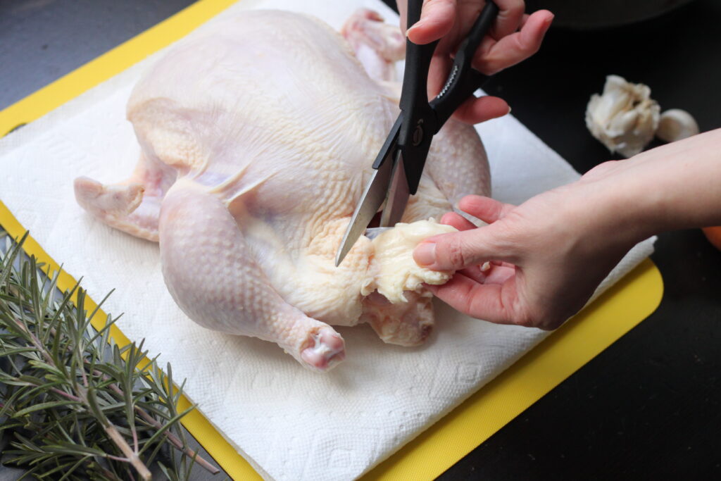 Removing the giblets from the chicken cavity to Smoked Whole Chicken 
