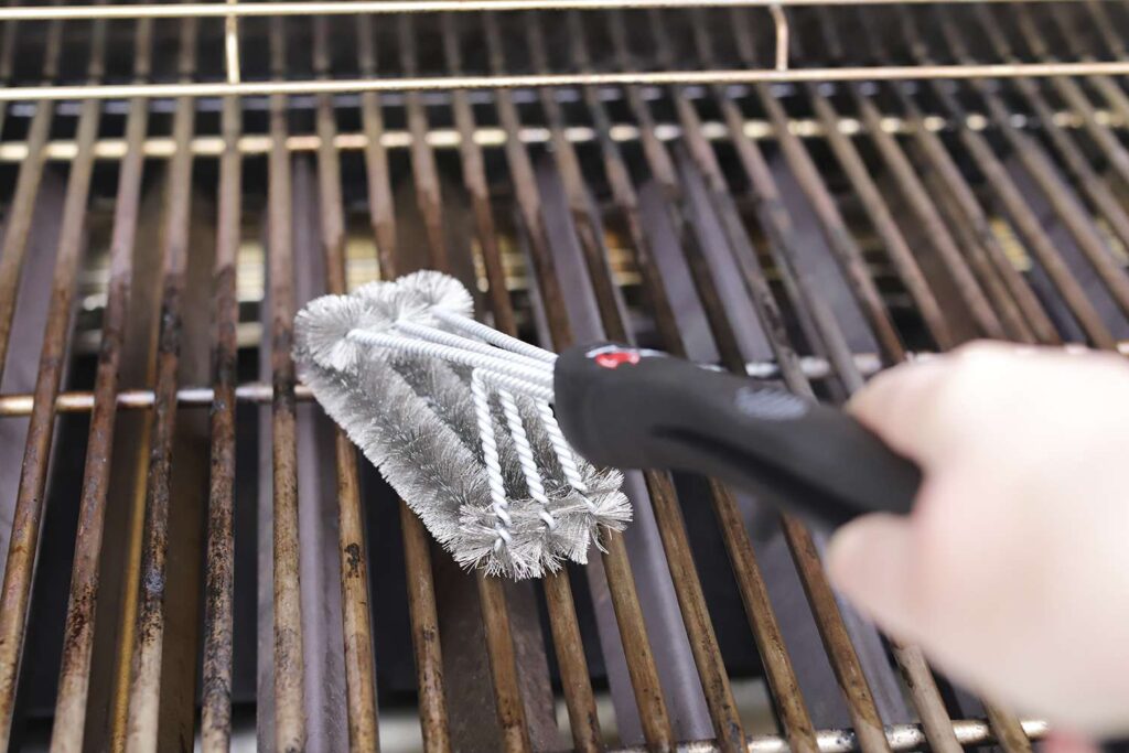 Cleaning BBQ grill with wire brush