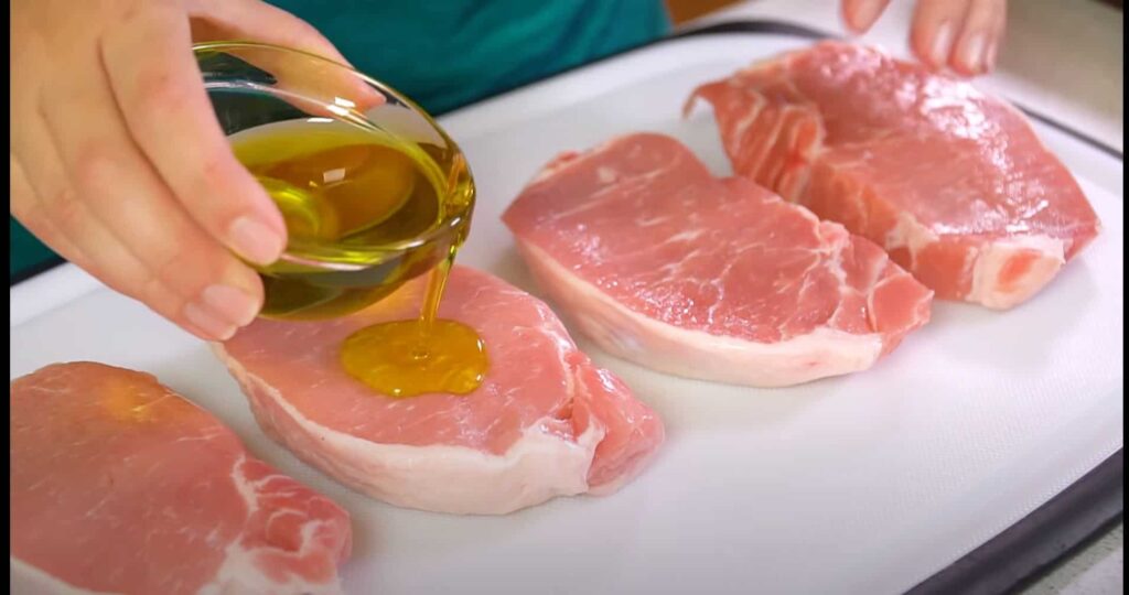 Place your seasoned pork chops on a baking sheet lined with foil and brushed with oil to prevent sticking